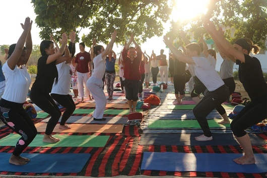 YTT students practicing Utkatasana in an outdoor surrounding Students practicing Utkatasana/ Chair Yoga during their YTT at Arhanta Yoga Ashram