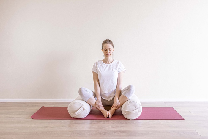 Baddha Konasana - Bound Angle Pose A young pregnant woman practices Bound Angle Pose to soothe symptoms of acid reflux.