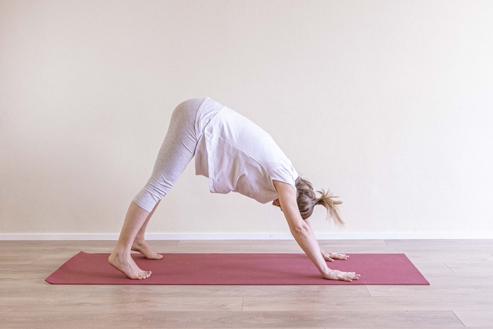 Adho Mukha Svanasana - Downward Facing Dog A young mom comes into downward facing dog yoga pose for pregnancy back pain.
