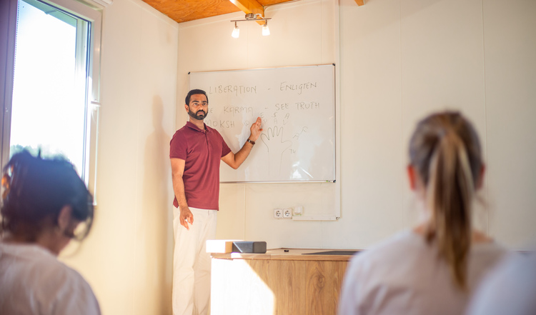 An Indian yoga teacher explains the history and philosophy of Hatha Yoga to a class of students at Arhanta Yoga An Indian yoga teacher explains the history and philosophy of Hatha Yoga to a class of students at Arhanta Yoga