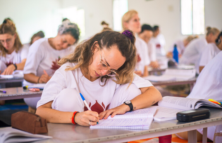 Yoga students attending theory sessions during their YTT Students taking notes in a theory class during YTT