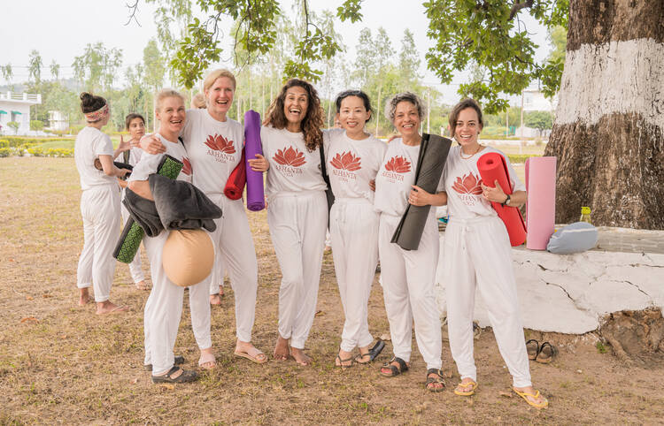Arhanta yoga students posing together after Hatha Yoga practice Group of arhanta yoga students posing in uniform after the class