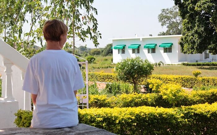 Yoga student reflecting quietly in a leisure afternoon at Arhanta Yoga Ashram YTT student unwinding in the Ashram garden