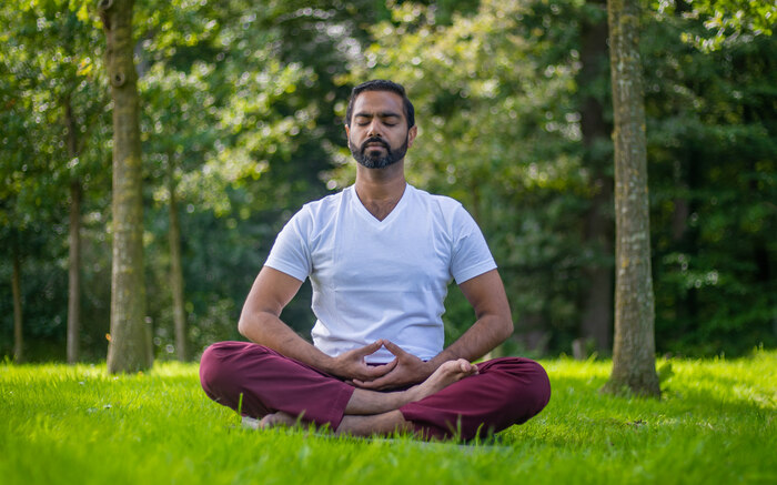A man practices yoga meditation outside A man practices yoga meditation outside