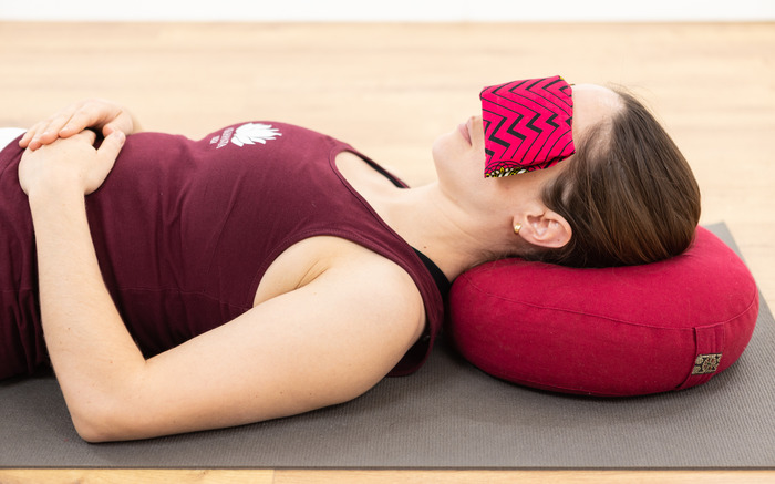 A woman practices yoga at home with props A woman practices yoga at home with props