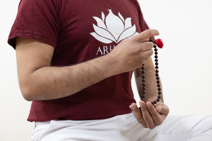A yoga practitioner hold mala japa beads in his yoga studio at home A yoga practitioner hold mala japa beads in his yoga studio at home