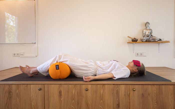 A yoga practitioner uses various yoga props to relax in Shavasana A yoga practitioner uses various yoga props to relax in Shavasana