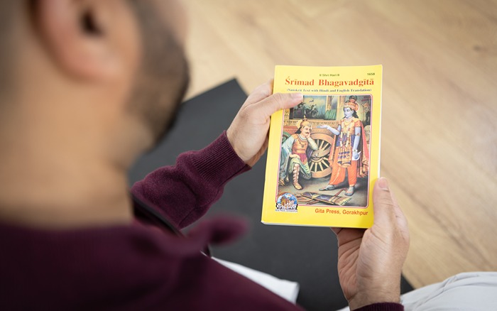 Yoga practitioner reads the Bhagvad Gita during svadhyaya Yoga practitioner reads the Bhagvad Gita during svadhyaya
