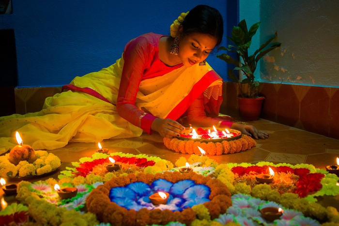 An Indian woman lights diyas during Diwali