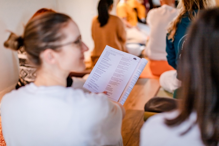 Beginner yoga teacher training students studying course material during a 200-hour YTT class session