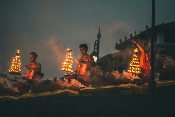 Men light incense beside the ghats during a ritual in Varanasi