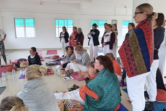 Yoga students watch a demonstration on a winter yoga teacher training in India Yoga students watch a demonstration on a winter yoga teacher training in India