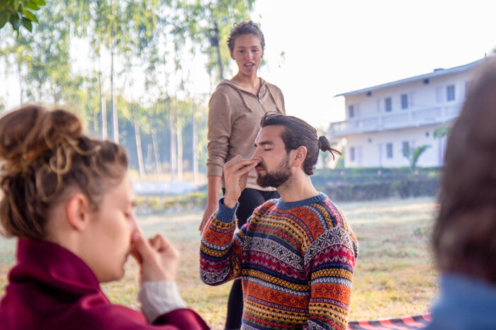 Yoga teacher guiding student with nadi shodhana Yoga teacher guiding student with nadi shodhana