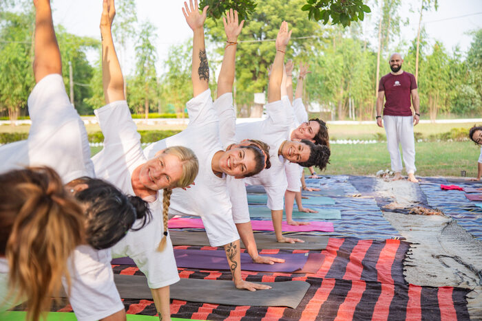 Students mastering side plank during their YTT asana practice session 200 YTT outdoor group session