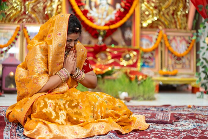 Traditional Indian Ceremony with Woman in Sari and namaste position