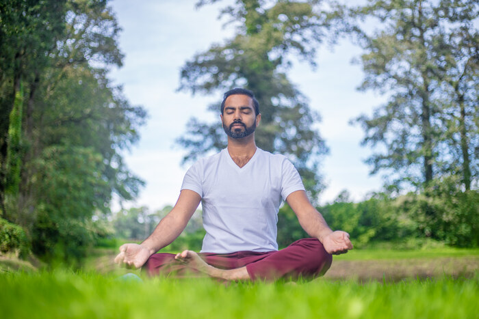Yoga practitioner meditates outdoors Yoga practitioner meditates outdoors