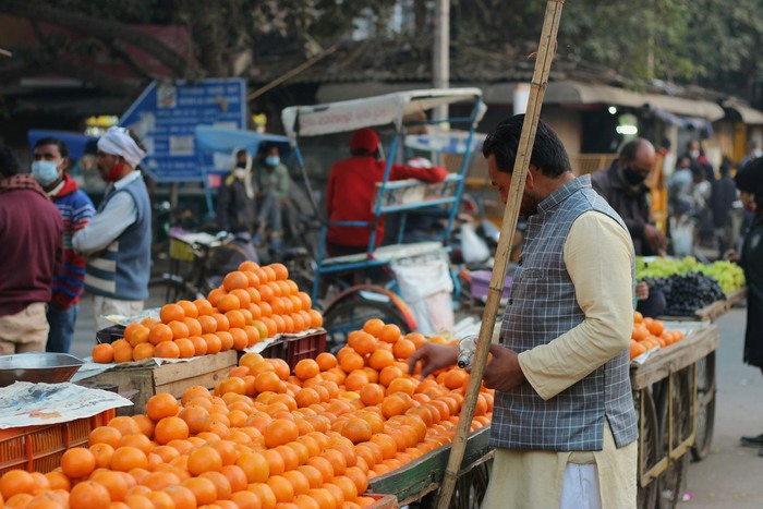 Man buys fruit at a market in Delhi, India