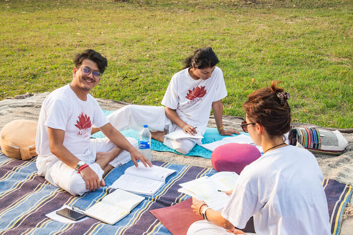 Yoga students study together outside in India