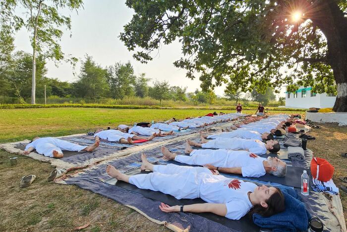 Yoga students relaxing in corpse pose in an outdoor yoga class