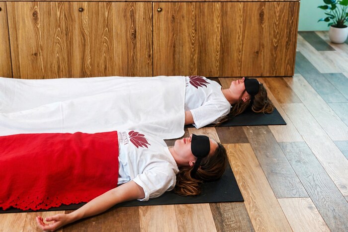 Two women practicing Yoga Nidra in an indoor setup Two women practicing Yoga Nidra in an indoor setup