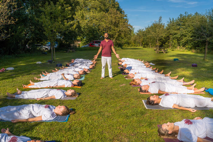 Yin yoga relaxation after practice Yoga teacher guiding students into deep relaxation after yin yoga practice outside yoga ashram