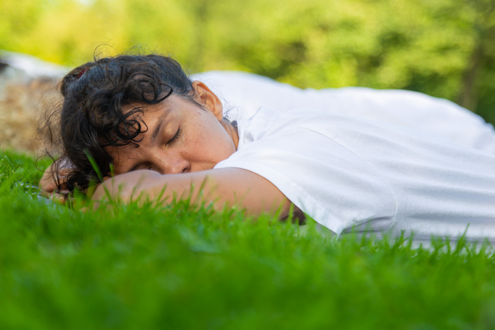 Yin yoga relaxation Yoga student lying down relaxing outside in nature before yin yoga class at ashram