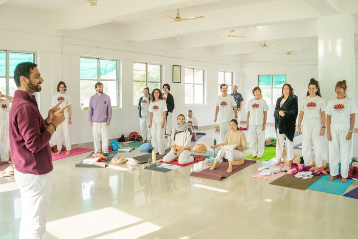 Mixed-age students in a yoga teacher training session Yoga teacher guiding a mixed-age group during a yoga teacher training class in a bright studio