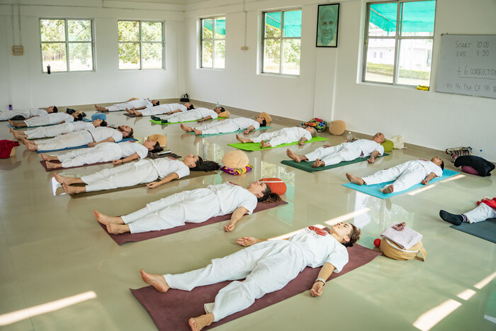 Students resting in Corpse pose, also known as Savasana