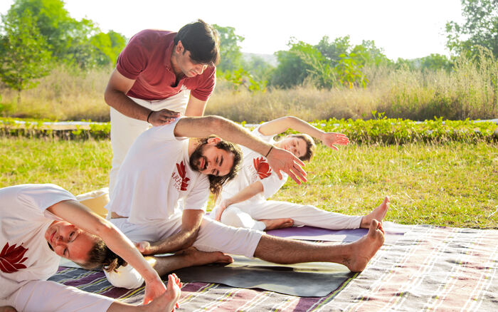 Master Yin Yoga Teacher helps a student hold a Yin Yoga Pose for a long duration - Characteristics of Yin Yoga