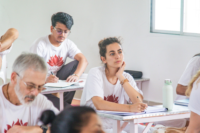 Yoga students taking notes in a theory yoga session