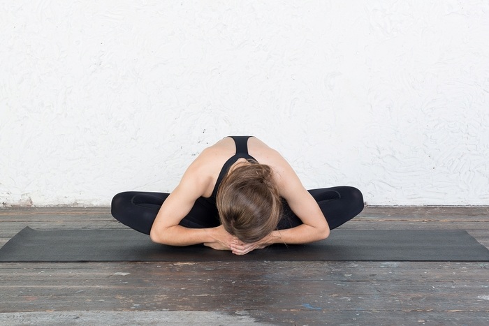 Woman practicing Butterfly Pose in Yin variation