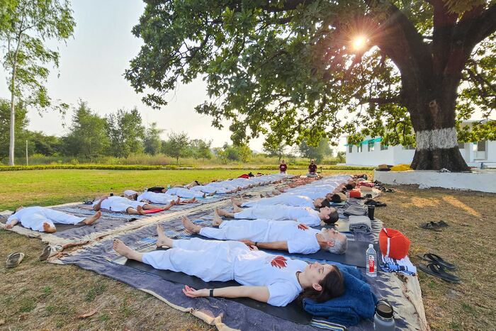 Outdoor corpse pose practice Yoga students practicing corpse pose during outdoor practice