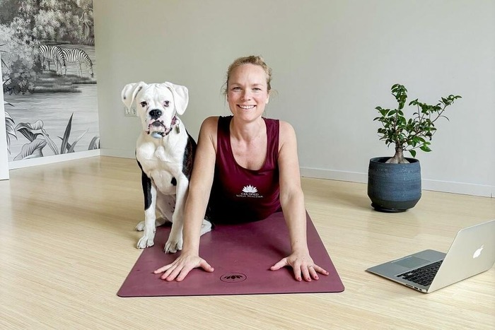 Woman practicing Cobra pose at home during online YTT